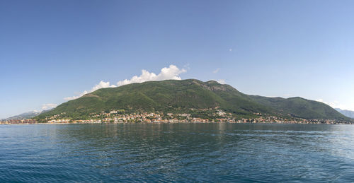 Scenic view of sea and mountains against blue sky