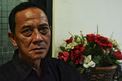 Portrait of man with red flower