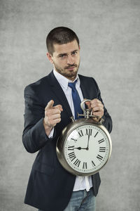 Portrait of young man standing against wall