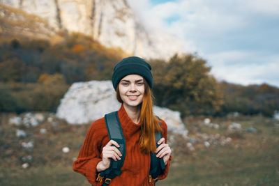 Portrait of smiling young woman standing in park during winter