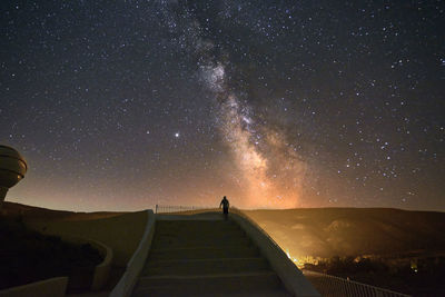 Person on grand staircase watching the milky way, stars, night time, long exposure