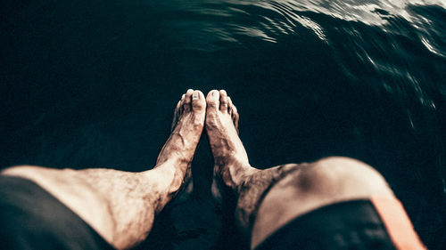Low section of man relaxing on water