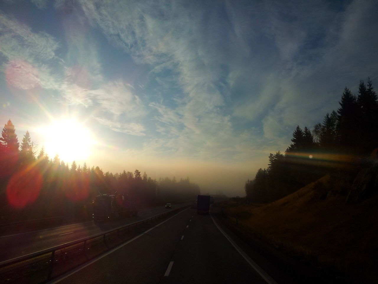 transportation, the way forward, sunset, road, sky, sun, diminishing perspective, vanishing point, sunbeam, road marking, country road, cloud - sky, sunlight, tree, landscape, nature, tranquility, car, tranquil scene, scenics