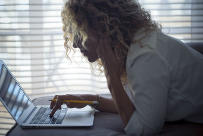 Side view of senior woman sitting at home