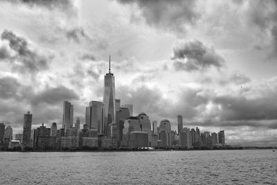 Buildings in city against cloudy sky