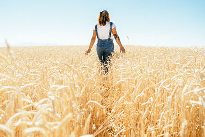 Woman standing on field against sky