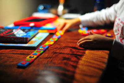 Cropped image of child hand playing with alphabet blocks on table