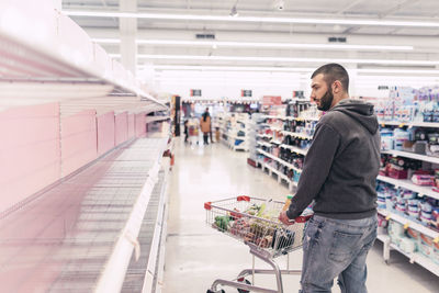 Man with shopping cart at supermarket