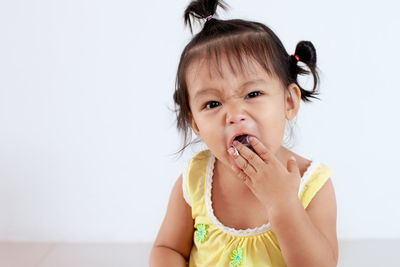 Close-up of cute baby girl eating at home