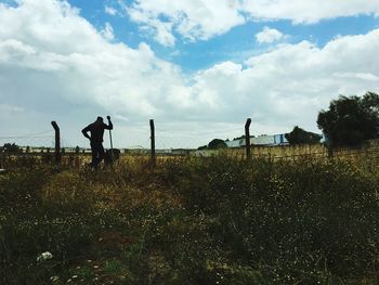 Men standing on field against sky