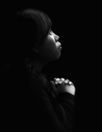 Close-up of woman praying against white background