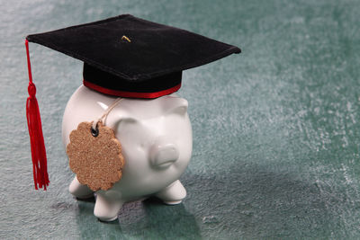 Mortarboard on piggy bank over table