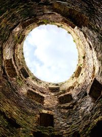 Low angle view of old sky seen through hole