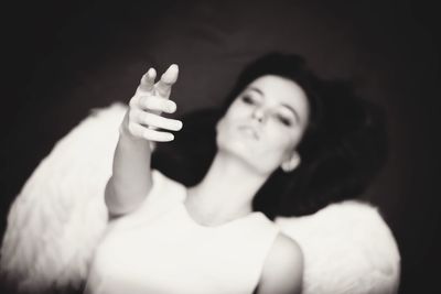 Close-up of woman with hand on black background