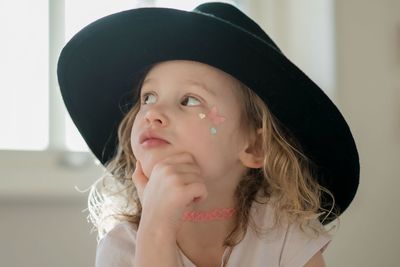 Portrait of a young girl with her face painted and fancy dress hat