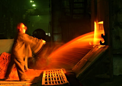 Blurred motion of man in illuminated factory