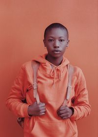 Portrait of young man standing against wall