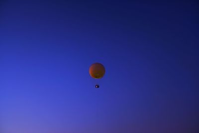 Low angle view of hot air balloon against clear blue sky