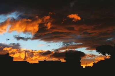 Low angle view of silhouette buildings against dramatic sky