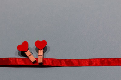 Close-up of red heart shape on table against wall