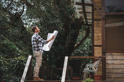 Side view of man standing against plants