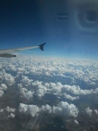 Aerial view of clouds over landscape seen from airplane