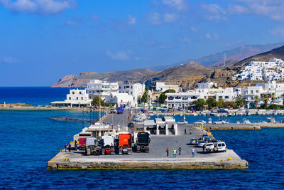 Boats in sea by buildings against sky