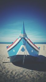 Deck chairs on beach against clear blue sky