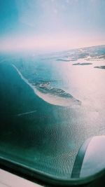 Aerial view of sea seen through airplane window