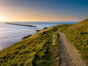 Couple enjoying elevated view of a ancient military pier in the water at pointe de la crèche