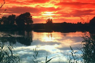 Scenic view of lake against orange sky