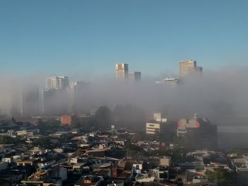 Buildings in city against clear sky