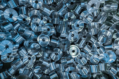 An industrial full frame background with a pile of shiny metal cnc aerospace parts. close-up.