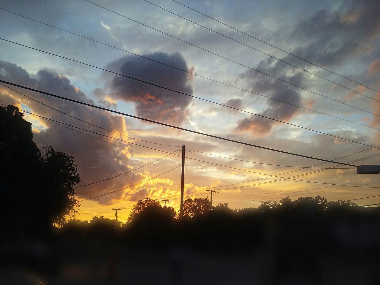 sunset, sky, silhouette, cloud - sky, cloudy, beauty in nature, scenics, cloud, nature, power line, orange color, tranquil scene, tranquility, dramatic sky, sun, weather, tree, landscape, low angle view, idyllic