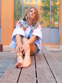 Happy woman sitting on wood