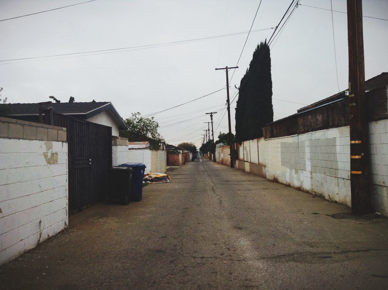 architecture, built structure, building exterior, the way forward, diminishing perspective, vanishing point, clear sky, sky, cable, street, connection, building, power line, city, long, transportation, outdoors, road, residential structure, day