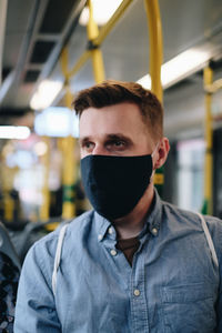 Close-up of man wearing mask in train