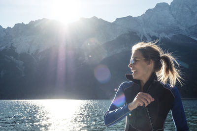 Germany, bavaria, garmisch partenkirchen, close up of young woman in wetsuit on lake eibsee