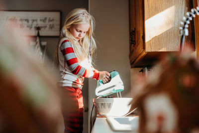 Portrait of girl cooking in kitchen with foreground out of focus 