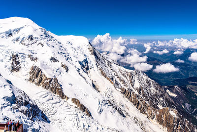 Scenic view of snowcapped mountains against blue sky