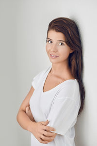 Portrait of a smiling young woman against white background