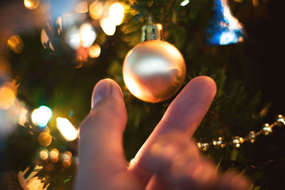 Close-up of hand holding illuminated christmas tree