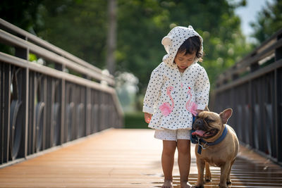 Girl walking with dog on footbridge