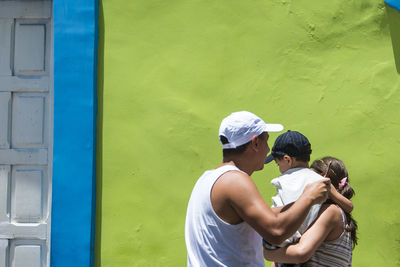 Rear view of couple standing against wall