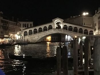 View of bridge over canal in city at night