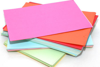 High angle view of multi colored papers on white background