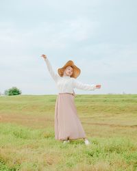 Woman with umbrella standing on field