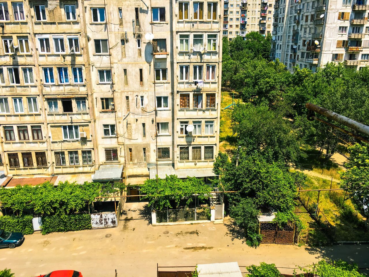 building exterior, architecture, built structure, tree, city, window, residential building, building, residential structure, growth, plant, balcony, green color, day, outdoors, potted plant, city life, incidental people, house, no people