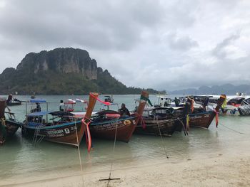 Boats moored on sea against sky