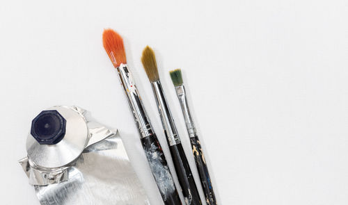 Close-up of paintbrushes against white background